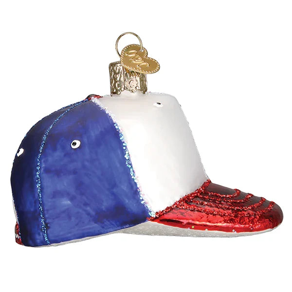 Decorative glass ornament shaped like a baseball cap with blue, white, and red colors on a white background.