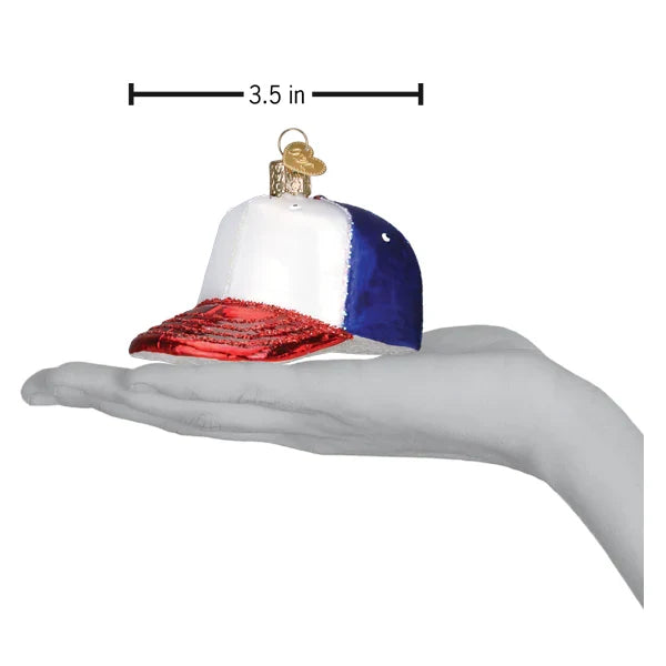 Decorative glass ornament shaped like a baseball cap with measurements on a white background