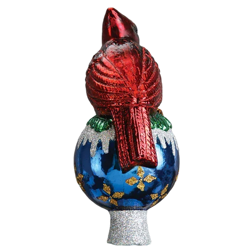 Back view of a red cardinal tree topper sitting on a blue ornament-shaped base with white glittered snow accents and gold details.