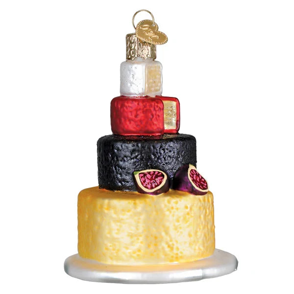 Decorative ornament resembling a multi-tiered cheeseboard with figs on a white background