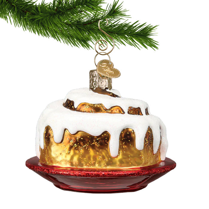 Cinnamon bun ornament hanging by a gold swirl hanger