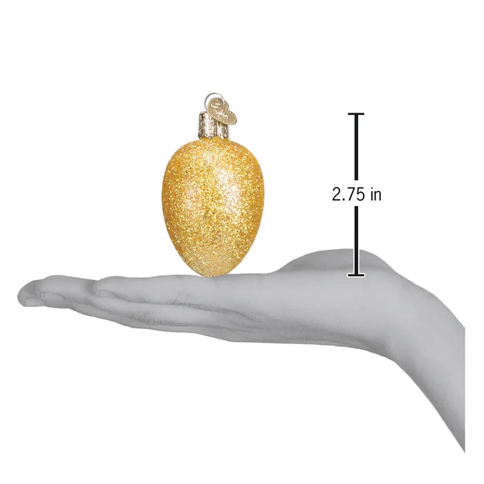 Gold glittery egg shaped Christmas ornament held in a hand with a measurement indicator showing 2.75 inches.