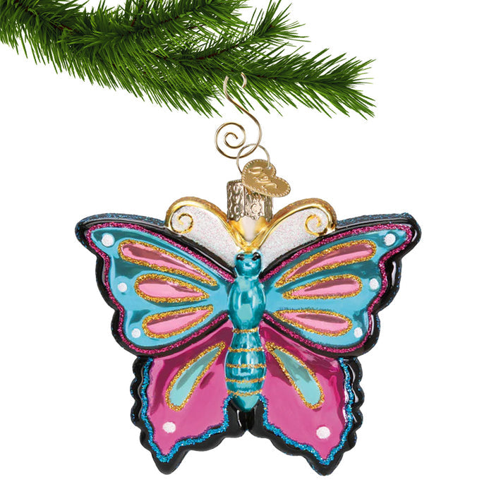 Glass Butterfly Ornament in blue, pink and purple hanging by a gold swirl hook from a Christmas tree branch