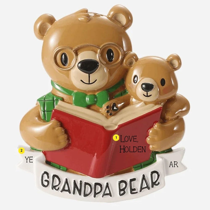 Personalized Grandpa Bear ornament with a bear in glasses and green bow tie reading a red book with a small cub and white banner for a year.