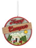 Round camper ornament with a red border, vintage trailer, pine trees, mountains, sunshine, and the phrase “Happy Camper.”