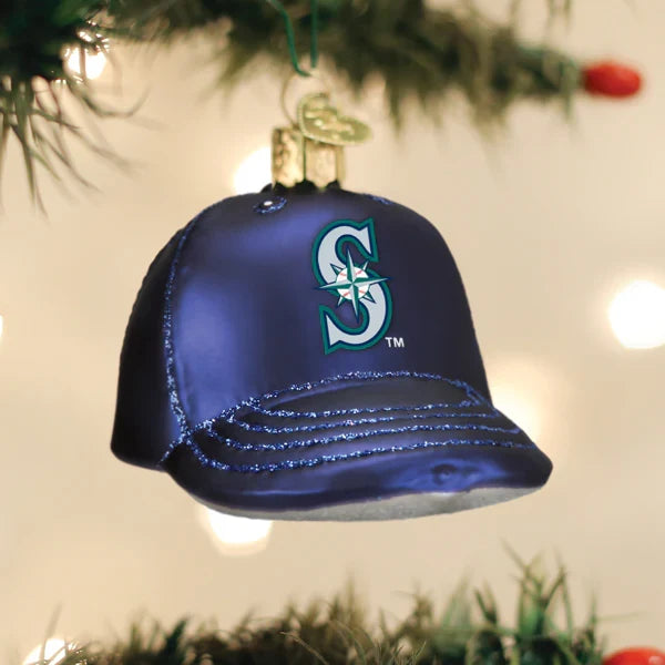 Blue baseball cap ornament with a Mariners logo, hanging on a Christmas tree.