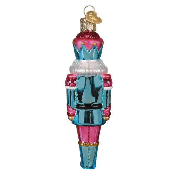 Decorative glass ornament shaped like a nutcracker on a white background
