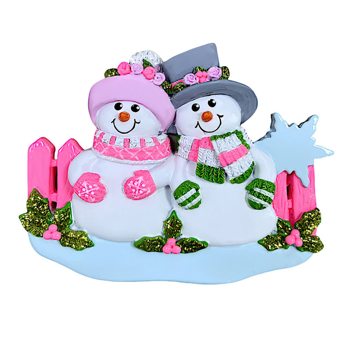 Decorative snowman couple ornament with pink and green accents on a white background