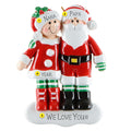 Decorative figurine of a couple in Christmas-themed outfits with text and numbers on a white background.