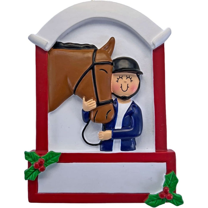 Equestrian ornament featuring a rider in a helmet beside a brown horse, framed by a red and white stable-style design with holly accents.