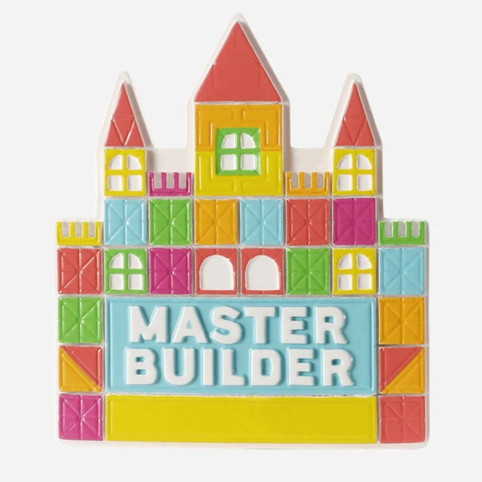 Colorful toy block ornament shaped like a castle with 'MASTER BUILDER' text on a white background