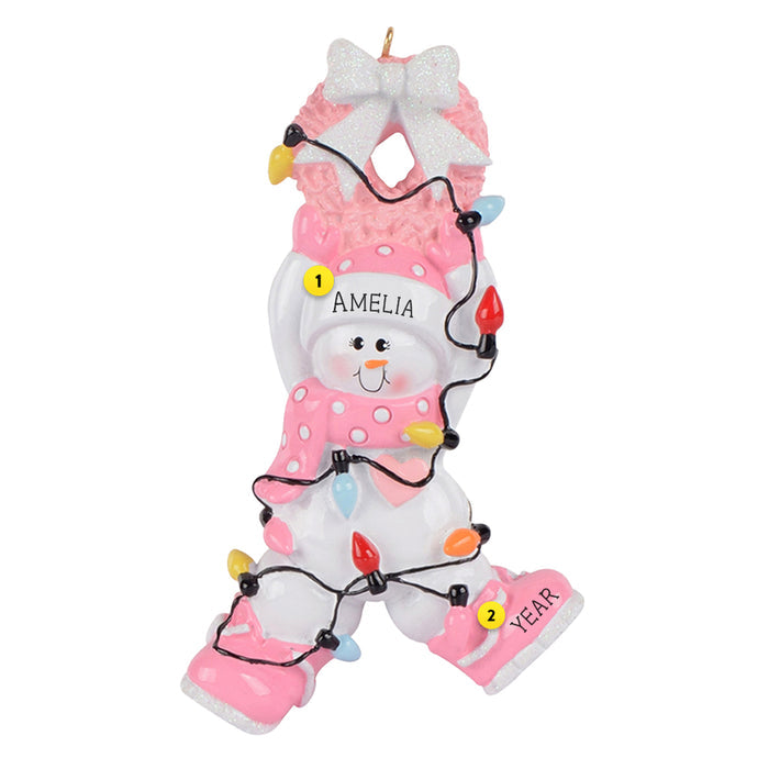 Personalized baby snow girl dressed in pink hanging from a pink Christmas wreath and tangled in lights ornament