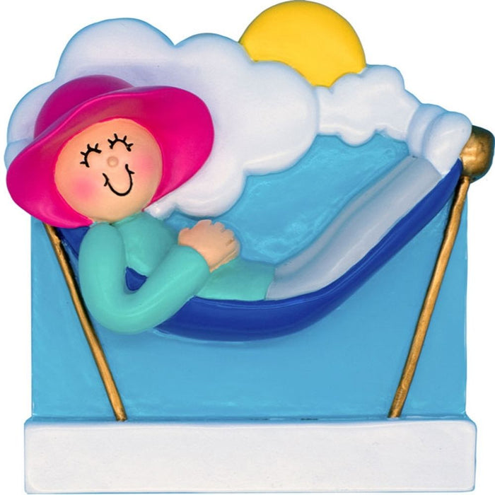 Ornament of a person lounging on a hammock with clouds in the sky with a pink hat.
