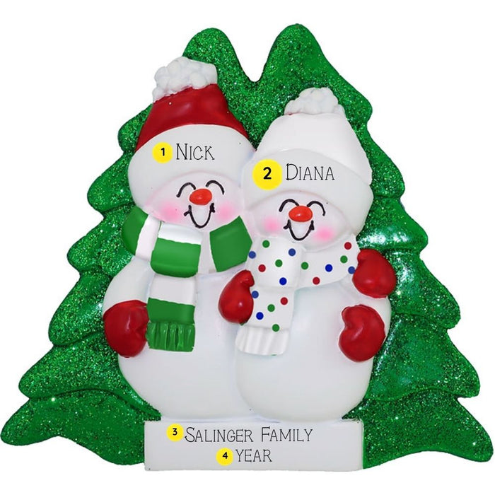 Personalized Christmas ornament with two snowmen and names on a green tree-shaped base.