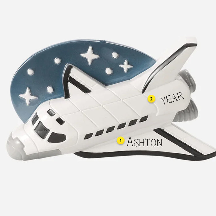 Space shuttle ornament can be personalized with name and year against a starry night sky background