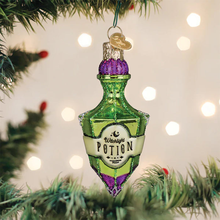 Decorative potion bottle ornament hanging on a Christmas tree with lights in the background.
