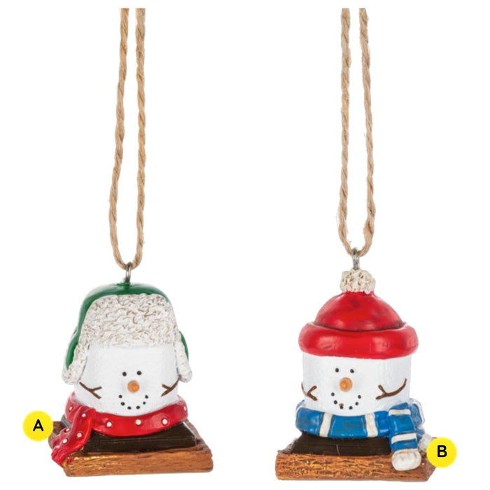 Two S’more Wintertime ornaments shown together, each featuring a marshmallow snowman-style figure on a graham cracker base dressed for winter, with one wearing a green trapper hat and red scarf and the other wearing a red hat and blue scarf.