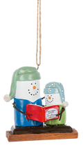 S’mores Story Time ornament featuring two marshmallow snowman-style figures in pajamas on a graham cracker base, reading a red Christmas book together.