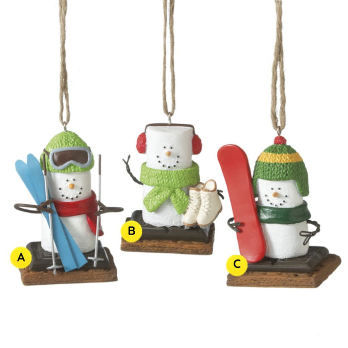Three S’mores Winter Sport ornaments shown together, each featuring a marshmallow snowman-style figure on a graham cracker base with a different cold-weather activity: skiing, ice skating, or snowboarding.