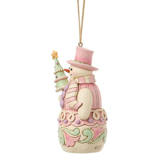 Side view of Jim Shore Sweets Snowman with Tree Ornament featuring pastel pink scarf, tiny Christmas tree, and candy-inspired details.