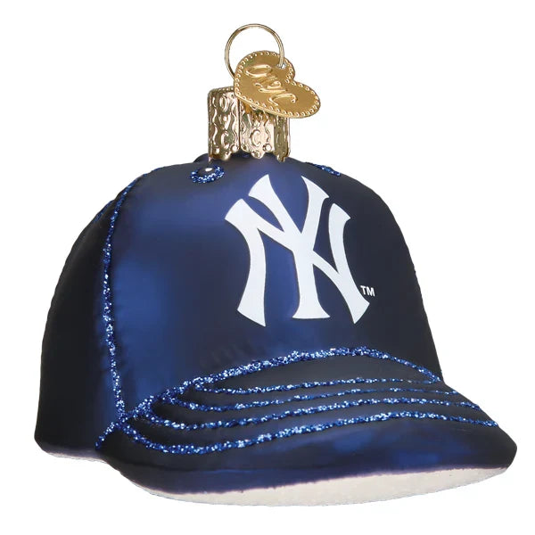 Glass ornament shaped like a blue baseball cap with a white New York Yankees logo on a white background